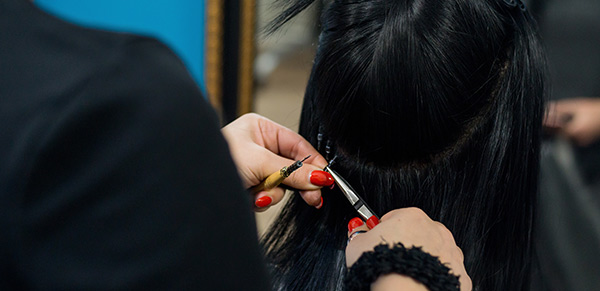 Hairdresser applying nano ring extensions