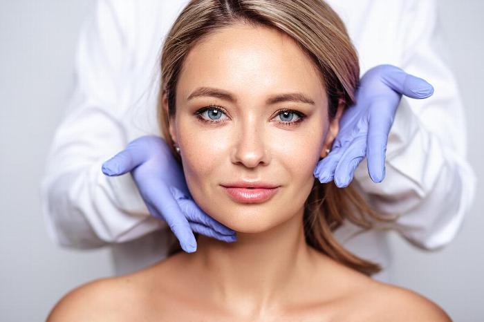 Woman looking at camera with surgeon behind her